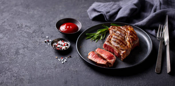 istock Beef Steak medium rare on a black plate. Grey background. Close up. Copy space. 2185256057
