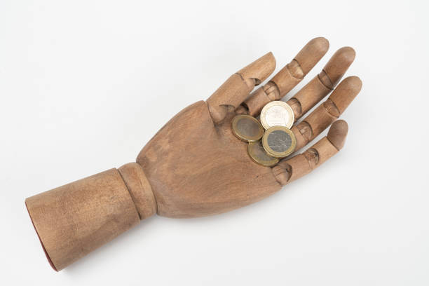 Some Euro coins in a wooden hand with a white background