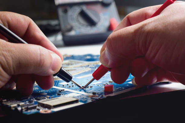 istock computer technician A laptop motherboard repairman is using an IC meter to find defects on the motherboard for repair on his work table. 2185256258