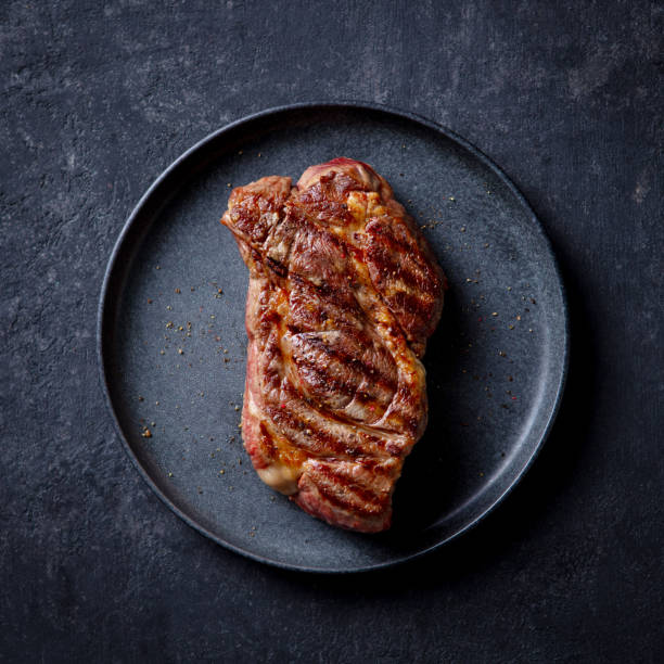 istock Beef Steak medium rare on a black plate. Dark background. Top view. 2185256371