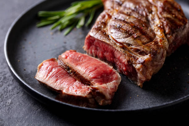 istock Beef Steak medium rare on a black plate. Grey background. Close up. 2185257531