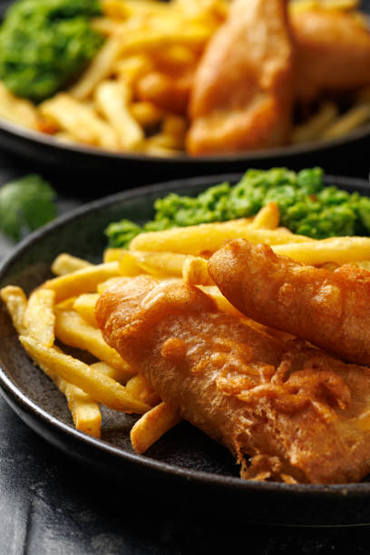 istock British Fish and chips with mashed peas, tartar and ketchup sauce. 2185263377