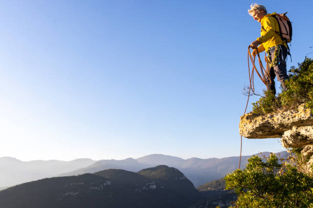 istock Mountain climber retrieves rope from rock summit 2185265399