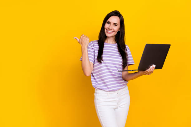 istock Photo of charming positive lady arm direct empty space offer quality cool modern device gadget netbook isolated on yellow color background 2185266266