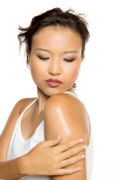 istock Young asian woman applying cream on bare shoulders. 2185267804