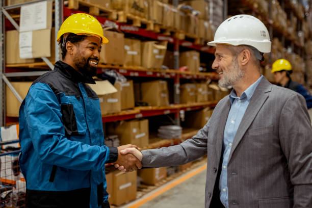istock Business Owner and Warehouse Worker Shaking Hands in Partnership 2185269009