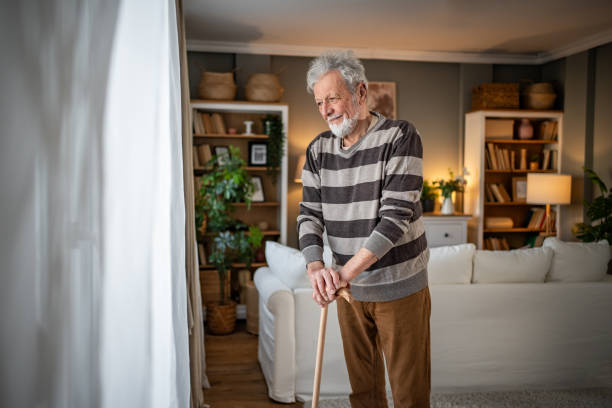 istock Peaceful everyday life, an old man stands by the window with a walking stick 2185269020