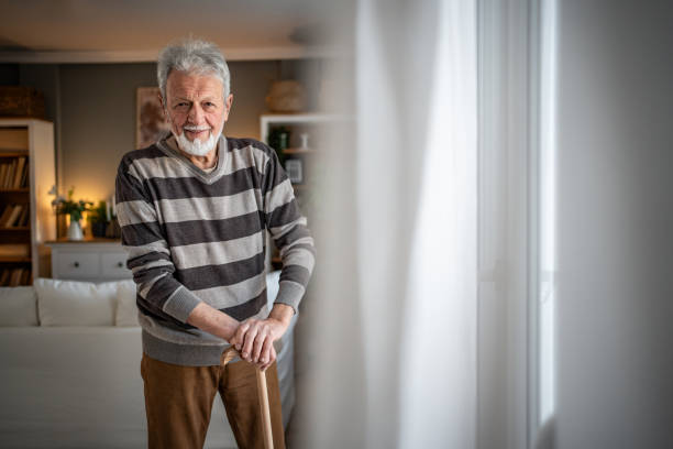 istock Peaceful everyday life, an old man stands by the window with a walking stick 2185269023