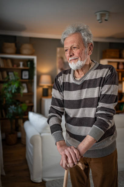 istock Peaceful everyday life, an old man stands by the window with a walking stick 2185269032