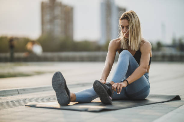istock Woman Tying Her Shoelaces While Exercising Outdoors 2185269082