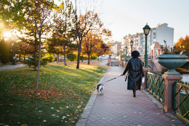 Young woman is strolling through the city with her dog.
