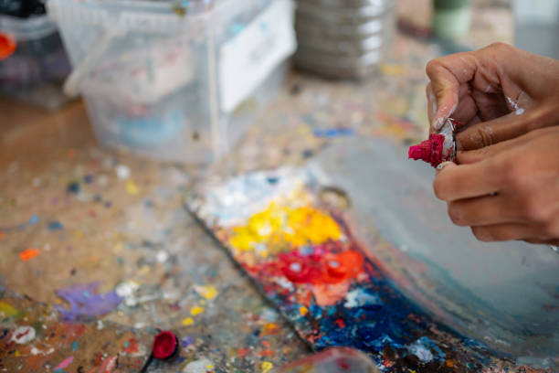 istock Artist squeezing paint tube on wood table in art studio 2185271440