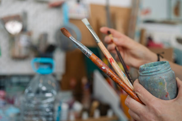 istock Artist holding paintbrushes and palette in art studio 2185271699