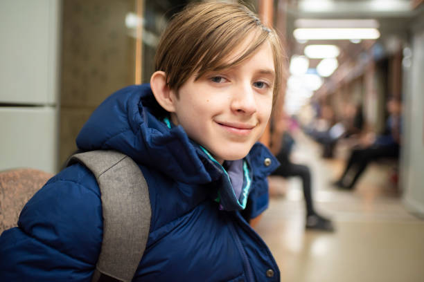 istock boy in a blue winter jacket sits in a subway train carriage 2185271782