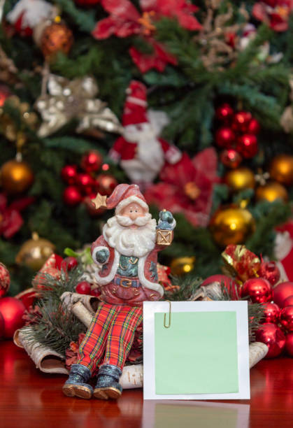 istock Santa Claus figurine holding a sign made with a blank sticky note for writing. 2185272490