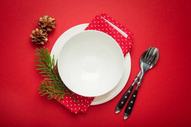 istock Christmas table setting decorated with pine cones and fir branches on red background 2185273562