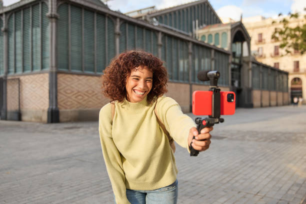 istock Young influencer filming vlog in urban setting with smartphone 2185273705
