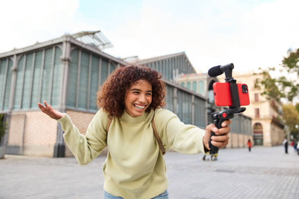 istock Young influencer filming vlog in urban setting with smartphone gimbal 2185273749