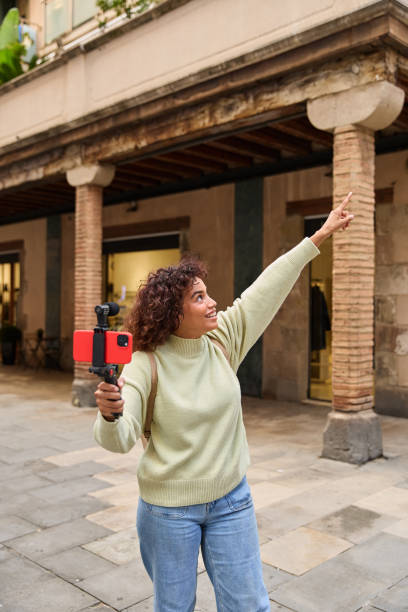 istock Influencer filming vlog in urban setting, pointing finger upwards 2185273799