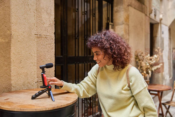 istock Young influencer filming vlog outdoors with smartphone and microphone 2185273989