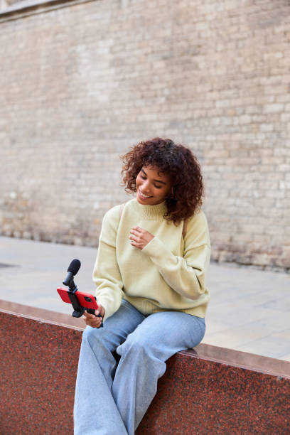 istock Young influencer filming vlog in urban setting using smartphone and microphone 2185274093
