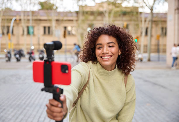 istock Young influencer filming vlog in urban setting with smartphone 2185274293