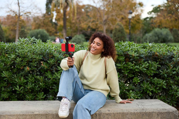 istock Influencer filming vlog in a park with smartphone and microphone 2185274523