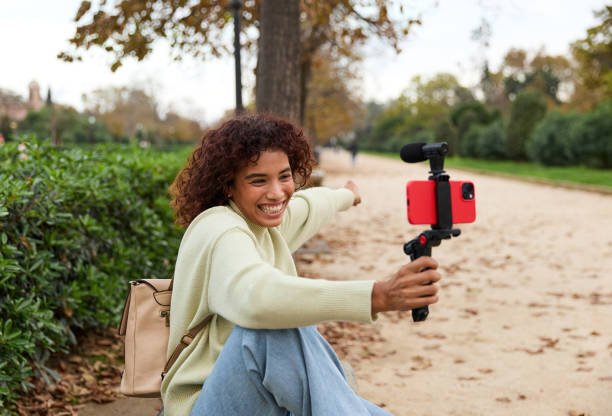 istock Young influencer filming vlog in a park with smartphone 2185274552
