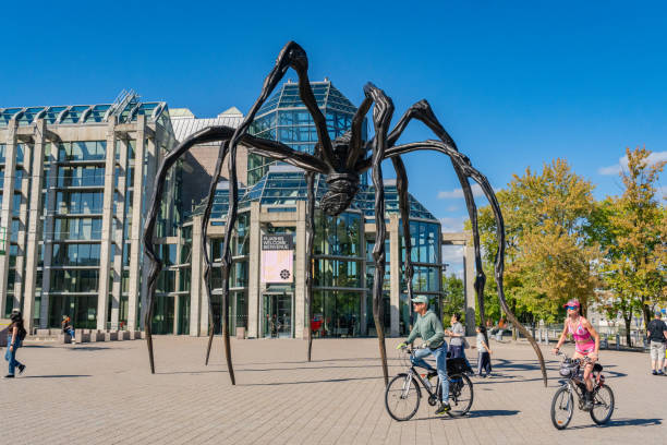 National Gallery of Canada Ottawa, ON, Canada-September 29, 2024: The Maman bronze sculpture of a large spider by the artist Louise Bourgeois near the National Gallery of Canada with tourists riding bikes. arthropod stock pictures, royalty-free photos & images