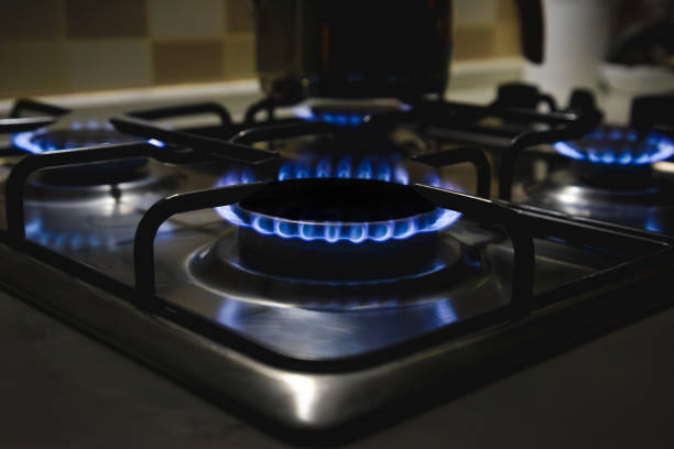 istock Natural gas burning on kitchen gas stove , Panel  with a gas ring burner on a black background, close-up shooting stock photo 2185281000