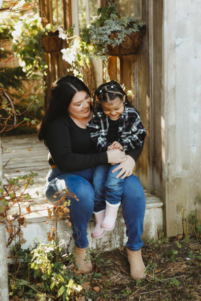 istock Little Girl and Mom on a Charming Rustic Porch 2185281300