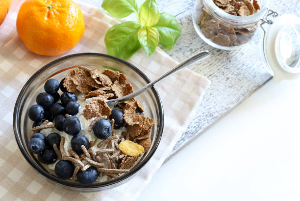 Wholemeal breakfast cereals, blueberries and yogurt isolated on white background. Healthy food. Copy space. Directly above.