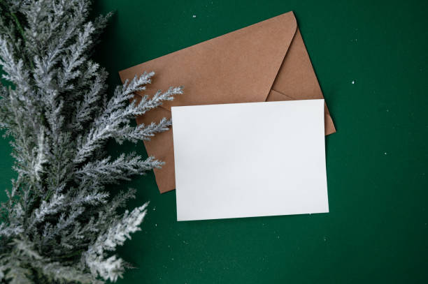istock Christmas card with place for text. Flat design. Open envelope with a blank sheet on a green background with a Christmas wreath. Copy space. Template for New Year's card. letter to santa 2185281851