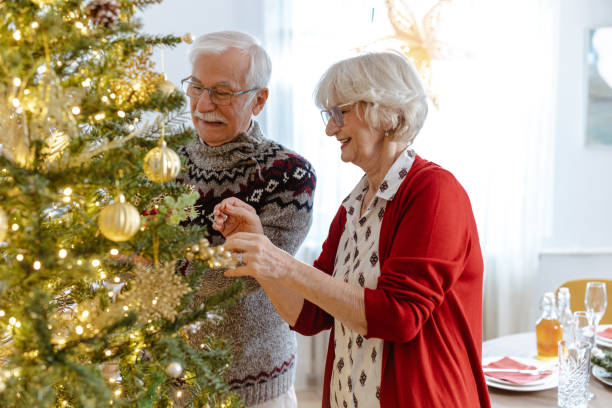 istock Elderly couple decorating a Christmas tree together at home 2185283917