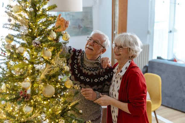 istock Senior couple decorating a Christmas tree with golden ornaments 2185283952