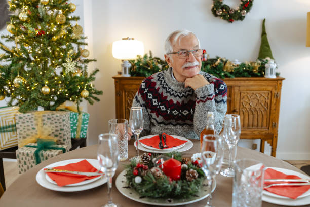 istock Senior man is sitting alone at a beautifully decorated Christmas table 2185285790