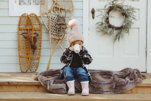 istock Little Girl on a Charming Rustic Porch Drinking Hot Chocolate 2185286220