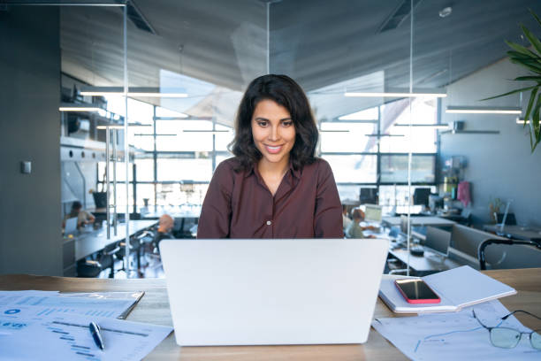 istock Young businesswoman professional employee using pc doing online banking analysing at workplace. Latin hispanic middle age business woman working on laptop computer in modern office. Banner, copy space 2185287801