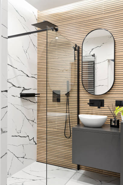 istock Interior decor. Ceramic bathroom sink with black water tap and tile with marbled effect on the wall and modern shower with glass. Real estate. Vertical. 2185290333
