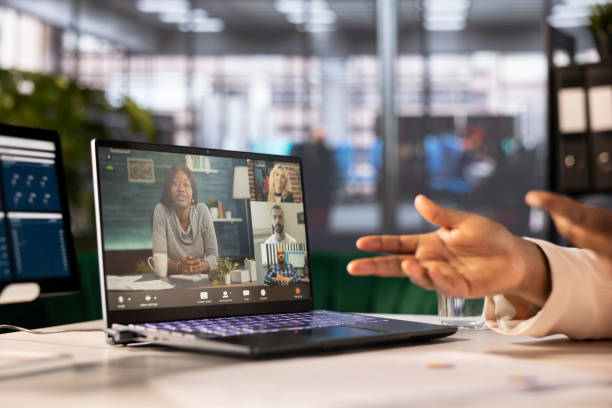 istock Team leader at computer desk in online videocall with remote teleworkers 2185291490