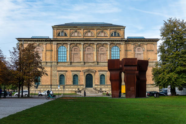 Munich, Germany - Oct 14, 2024: Main facade of the Old Pinakothek museum with the abstract sculpture by Eduardo Chillida called Buscando la Luz in front of the building.