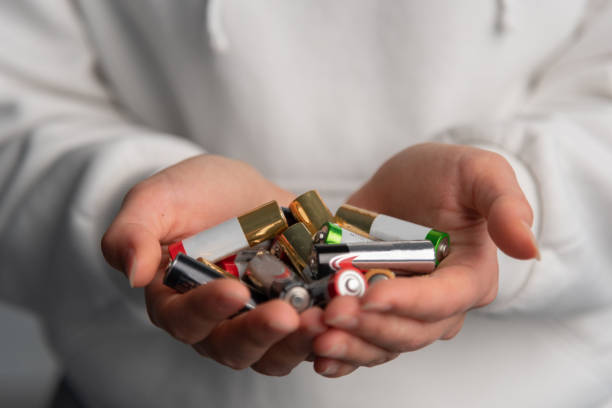 istock close up view of hands with alkaline batteries 2185295335