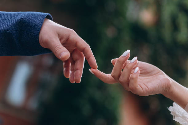istock close up view of two hands, bride and groom 2185295400