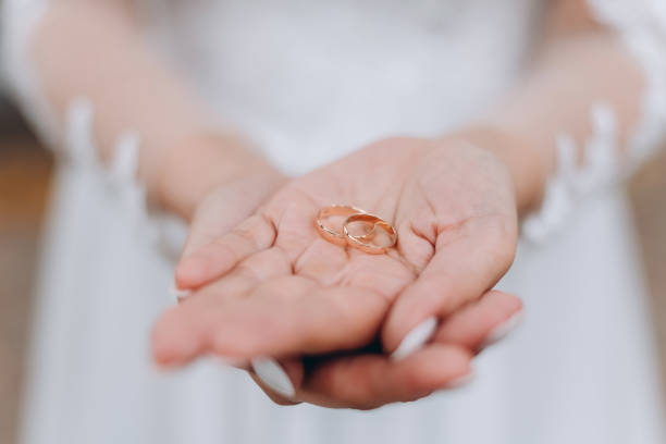 istock close up view of two hands holding wedding rings 2185295418
