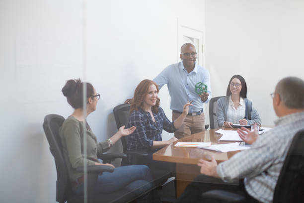 istock Group of multiracial work colleagues discuss scientific model innovation prototype device while sitting at conference table in meeting in office 2185295810