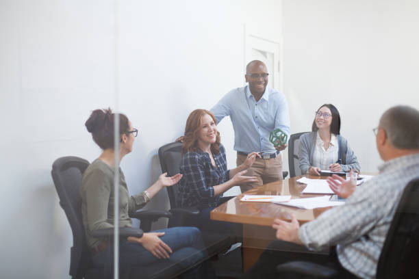 istock Group of multiracial work colleagues discuss scientific model innovation prototype device while sitting at conference table in meeting in office 2185295830