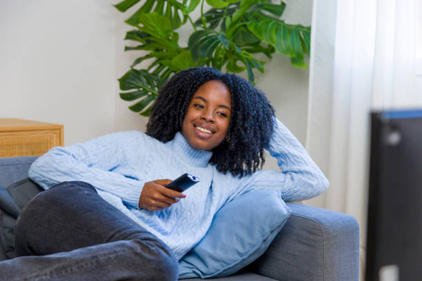 istock Young woman relaxing on sofa watching television 2185297358