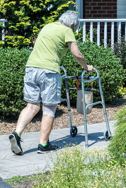 istock Tired Knee Replacement PT Patient Slowly Pushing Walker Up Ramp 2185298845