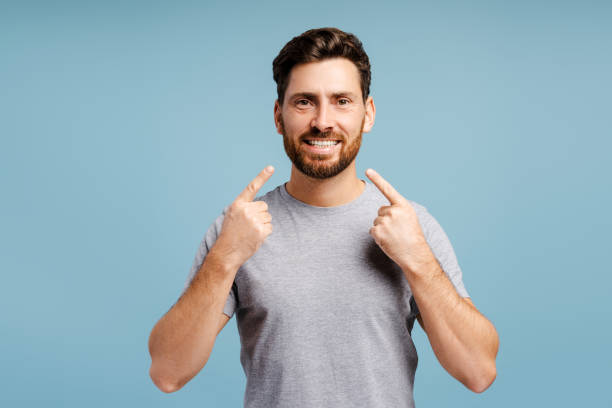 istock Handsome, bearded Hispanic man pointing finger on teeth smile, posing isolated on blue background 2185299709
