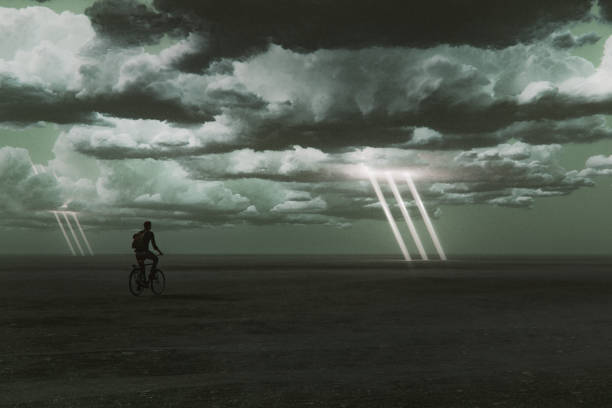 istock Man cycling in surreal flat landscape with storm clouds 2185300076
